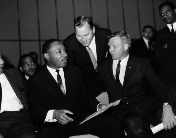 Mayor Jerome Cavanagh, standing, speaks with Dr. Martin Luther King, Jr., seated. Circa 1960s